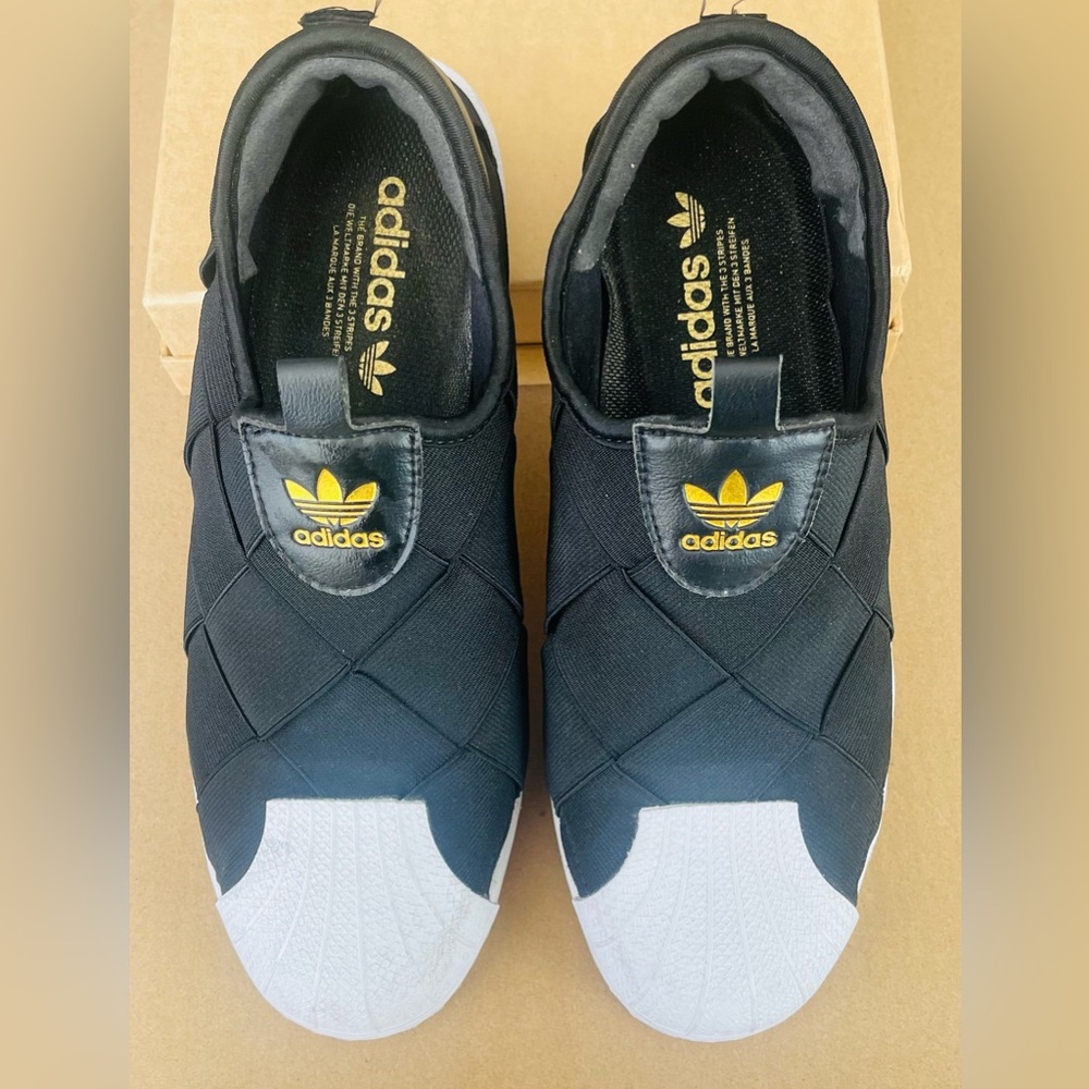 Adidas women’s Black and White Slip-On Sneakers